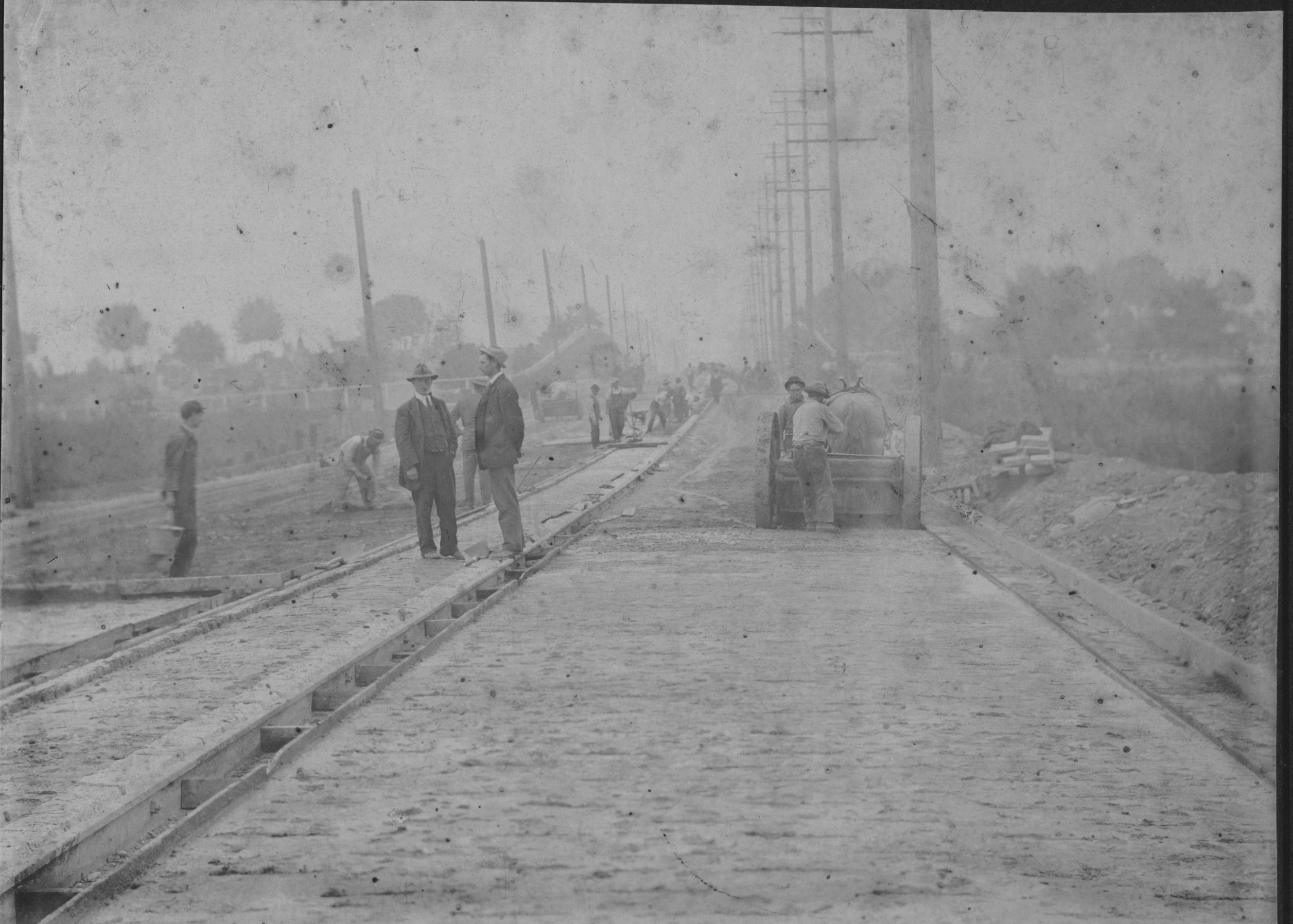 Two men supervising work along 33rd Avenue in South Vancouver District